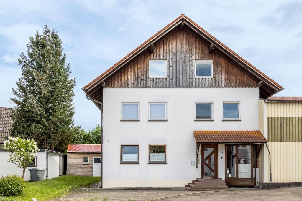 a white house with a wooden roof at Ferienwohnung-4you in Sigmarszell