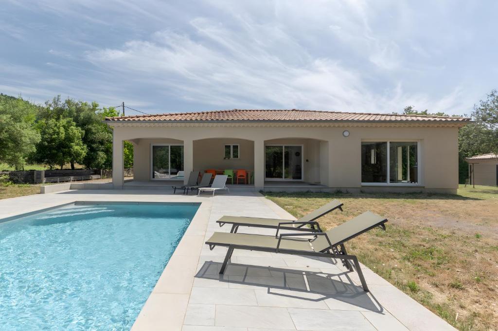 a villa with a pool and a house at Villa La Barbière in Sallelles