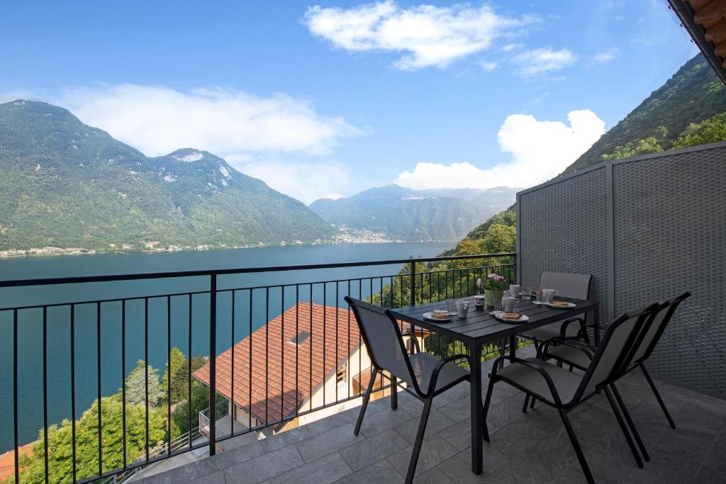 a table and chairs on a balcony with a view at Appartamento 6 Il Tornante in Nesso