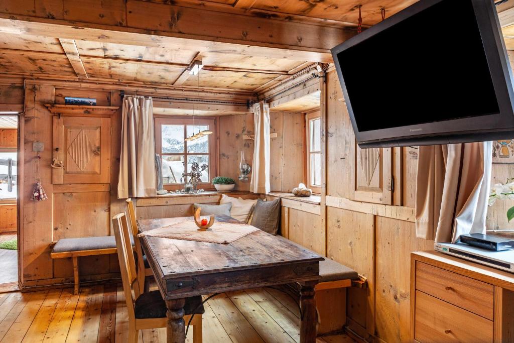 a dining room with a table and a flat screen tv at Liberty Ranch Marlstein in Oetz