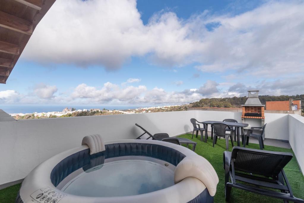 a balcony with a hot tub and tables and chairs at Vv El Mirador in El Palmital