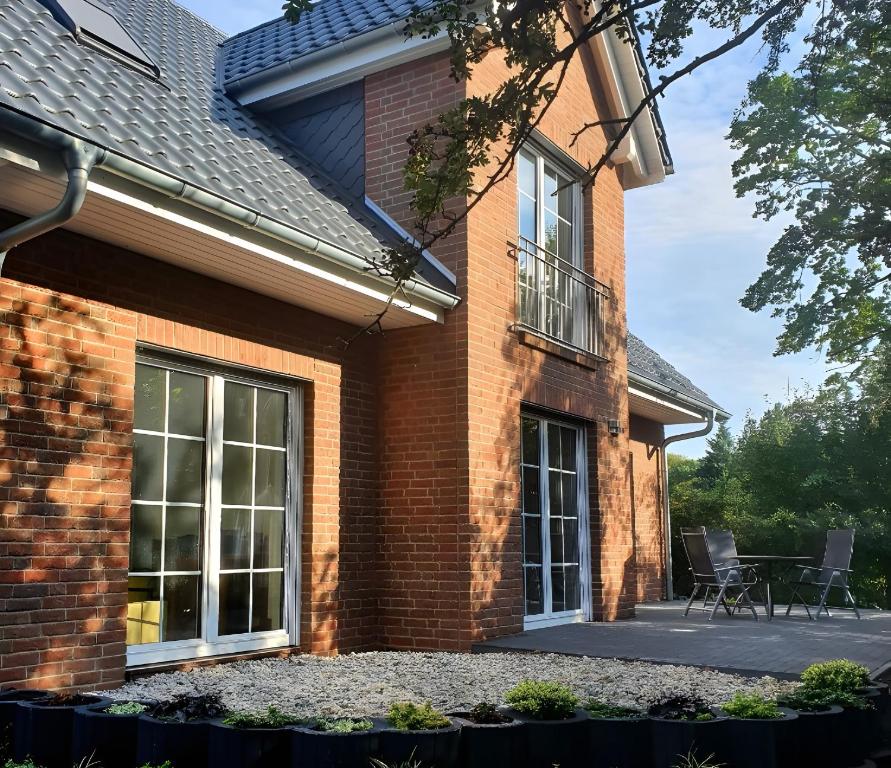 a brick house with two windows and a patio at Gästehaus Lean in Potsdam