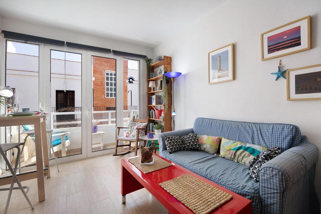 a living room with a blue couch and a table at Apartamento Caepionis in Chipiona