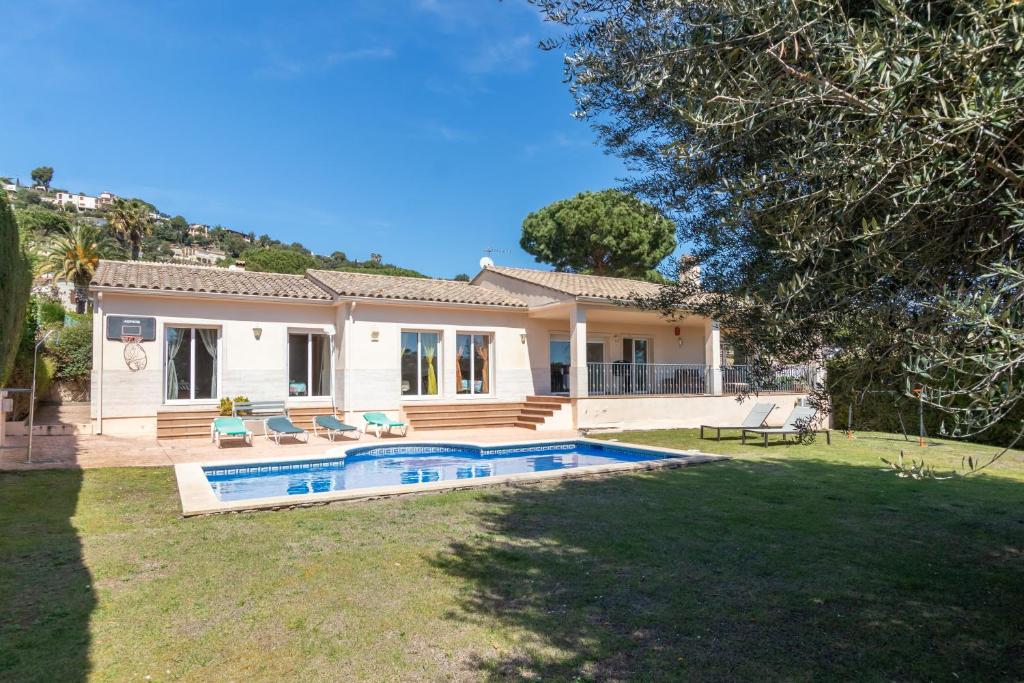 a house with a swimming pool in a yard at Villa Elodia in Calonge