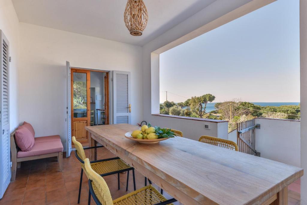 a dining room with a table with a bowl of fruit at Casa Magnolia P1 in Seccheto