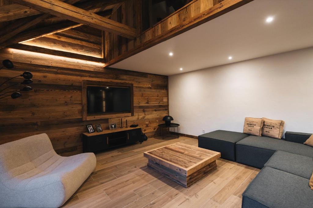 a living room with a couch and a tv at Gîte Maria in La Tour
