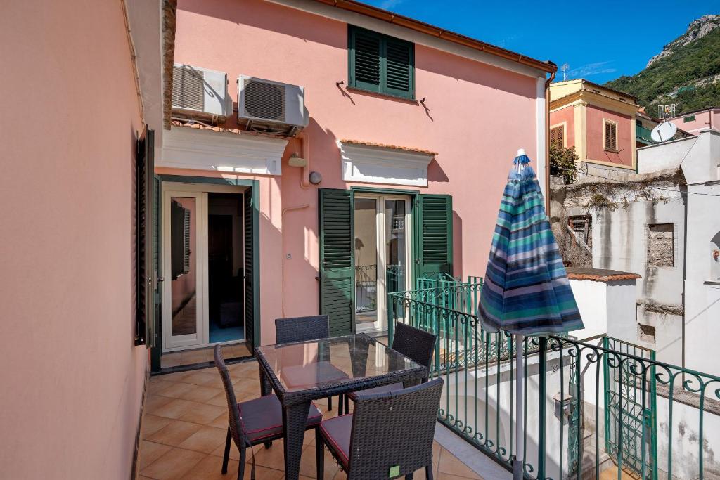 a balcony with a table and chairs and an umbrella at Ce Tour - Casa Cetara Centro in Cetara
