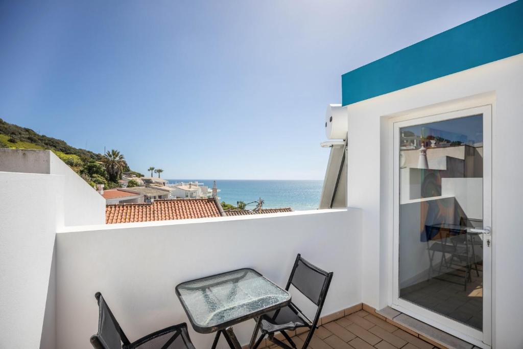 a balcony with chairs and a view of the ocean at Casa Da Paz in Salema