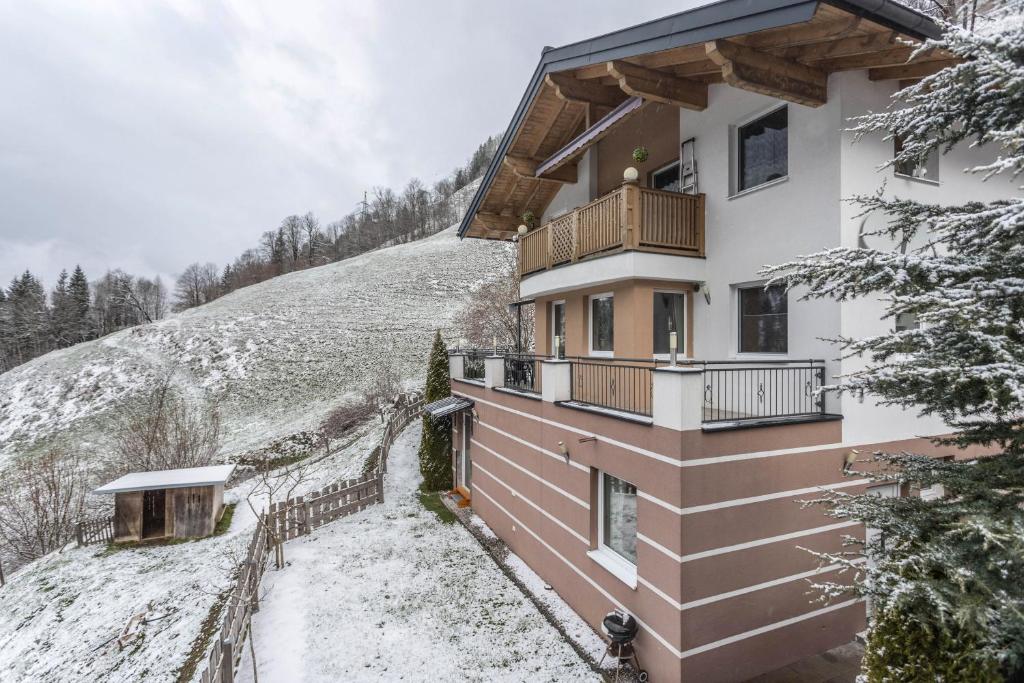 a house with a balcony on a snowy hill at Chalet Berger in Sankt Johann im Pongau