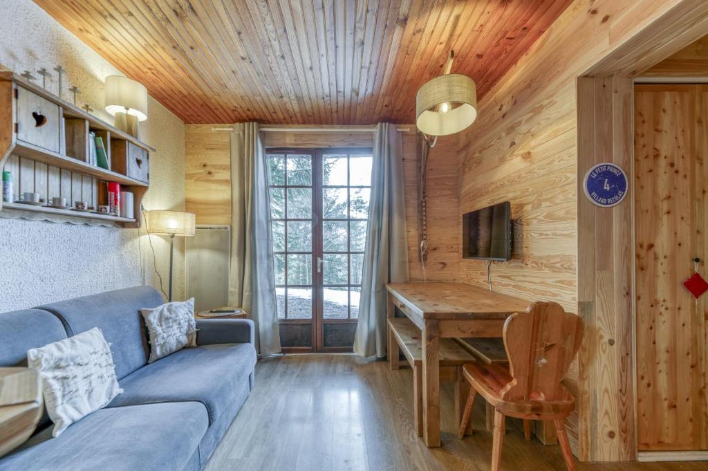a living room with a blue couch and a table at Gawal 1 in Villard-Reculas