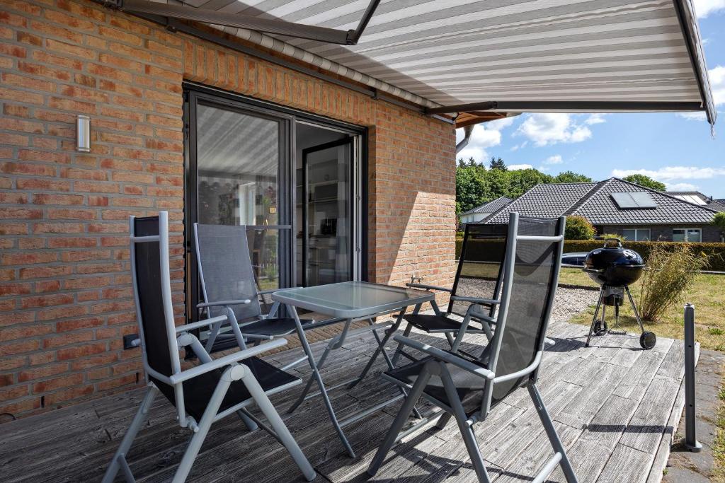 a patio with chairs and a table and a grill at Ferienwohnung Sunny in Beckdorf
