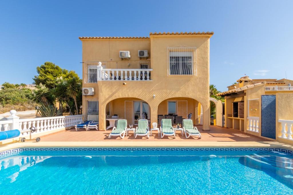 a villa with a swimming pool in front of a house at Casa Maravilla in Benitachell