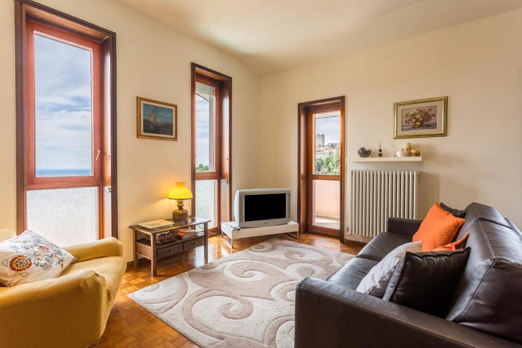 a living room with a couch and a tv at Attico Panoramico in Brunate