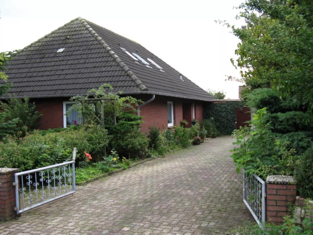 a brick house with a black roof and a driveway at Ferienhaus Ockholm in Ockholm
