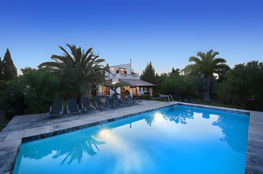 a swimming pool with chairs and a house at Can Toni in El Port