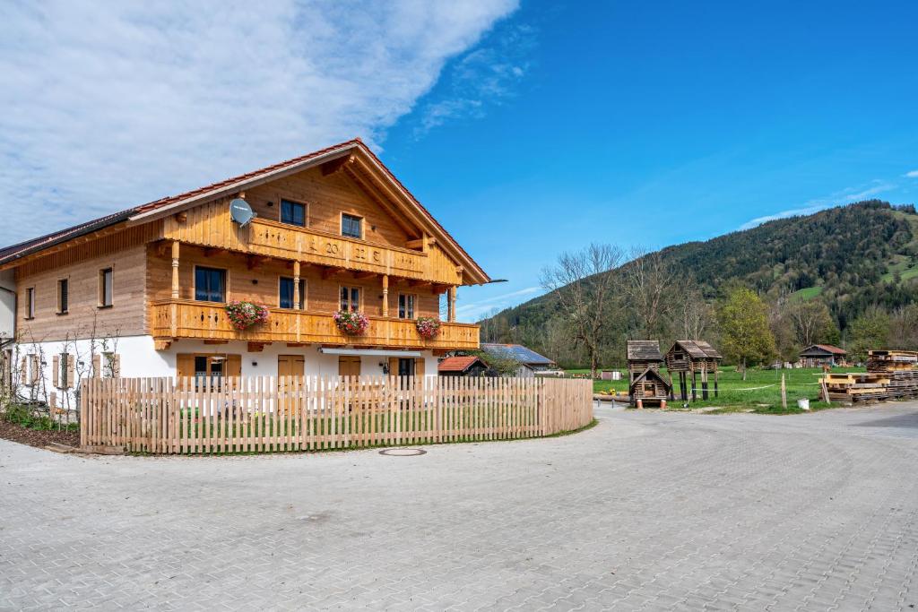 a wooden house with a fence in front of it at Wohnung Brauneck in Gaißach