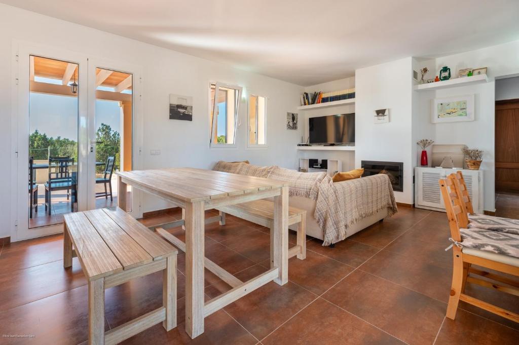 a living room with a table and a couch at Es Camp in Cala Saona
