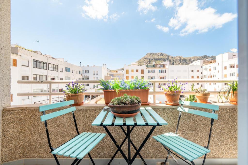 a balcony with two chairs and a table with a potted plant at Taiko in Port de Pollensa