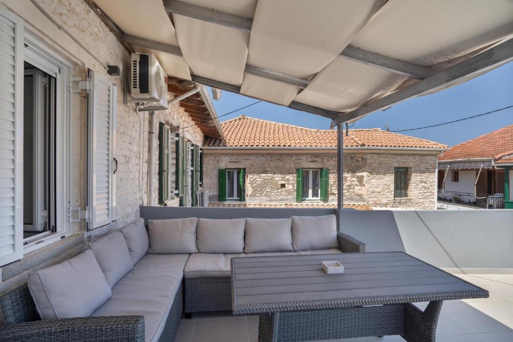 a patio with a couch and a table on a balcony at Casa Sparto in Meganisi