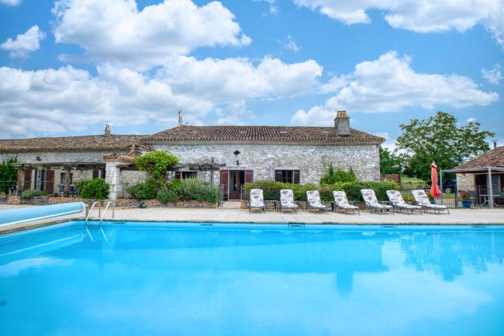 a house with a swimming pool in front of a building at La Ferme in Razac-dʼEymet