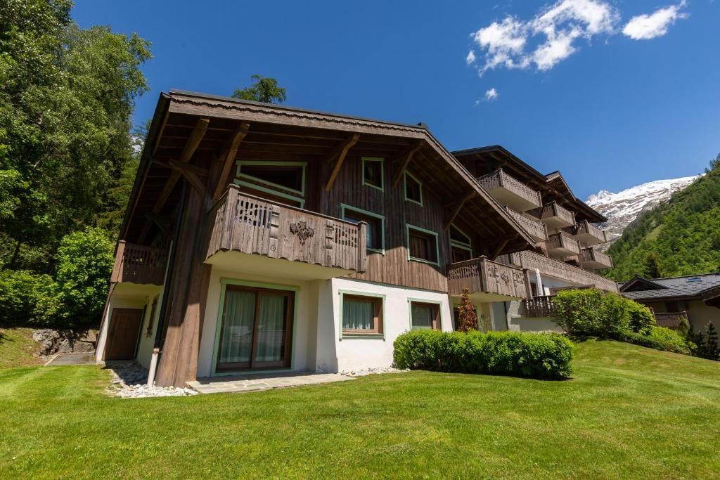 a house with a balcony on top of a yard at Residence Bec in Chamonix