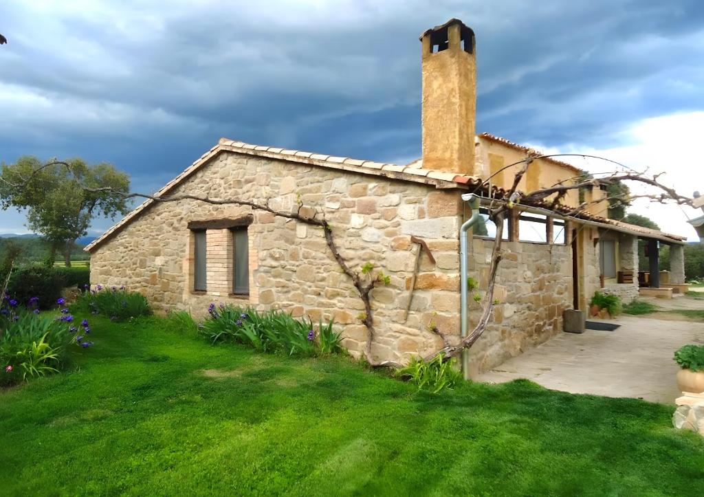 an old stone house with a grass yard at El Porxet in Navés