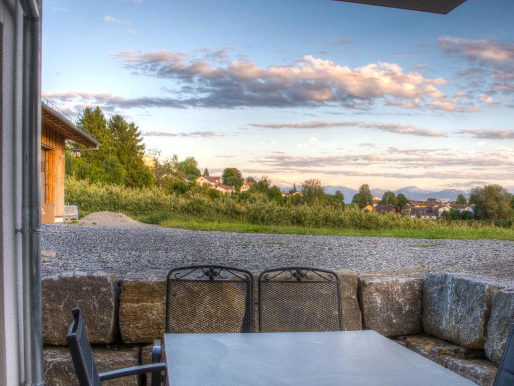 a table and chairs on a patio with a view of a road at Alpenblick 1 in Lindau-Bodolz
