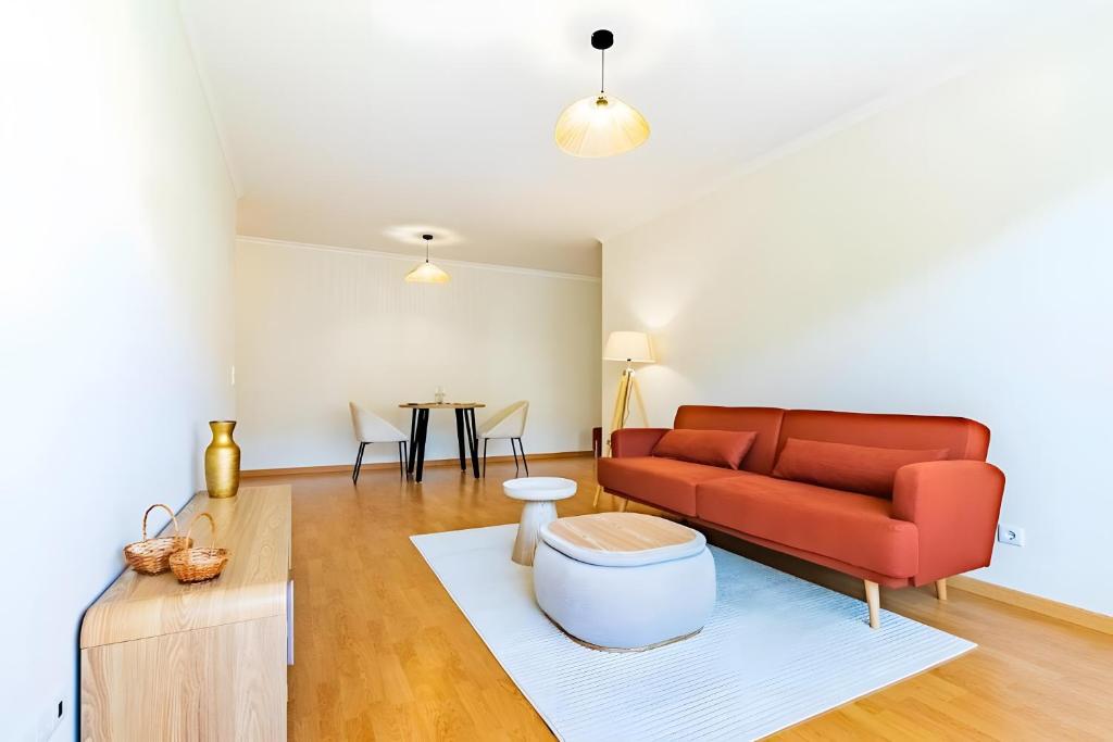 a living room with a red couch and a table at Casa Sol in Caniço