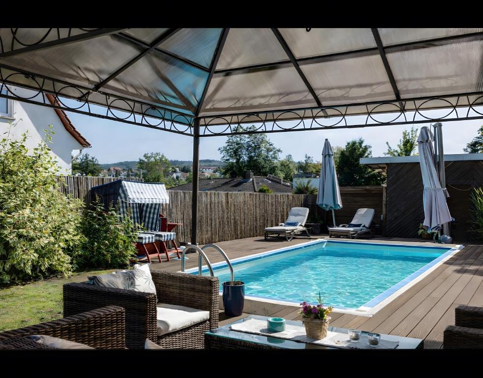 a backyard with a swimming pool and an umbrella at Ferienwohnung Efzeglück mit Pool in Homberg