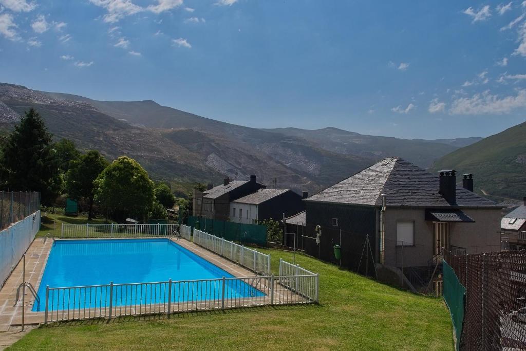 a swimming pool in a yard with mountains in the background at Pisos Leopoldo - Casaio in Casayo
