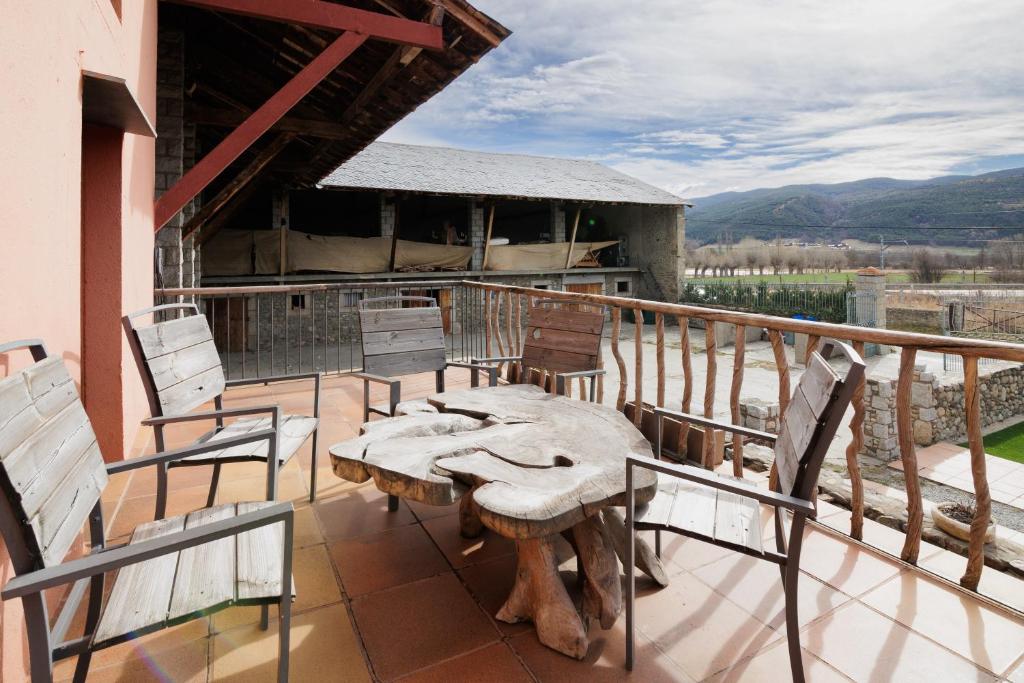 a patio with a table and chairs on a balcony at Masia d'en cot in Puigcerdà