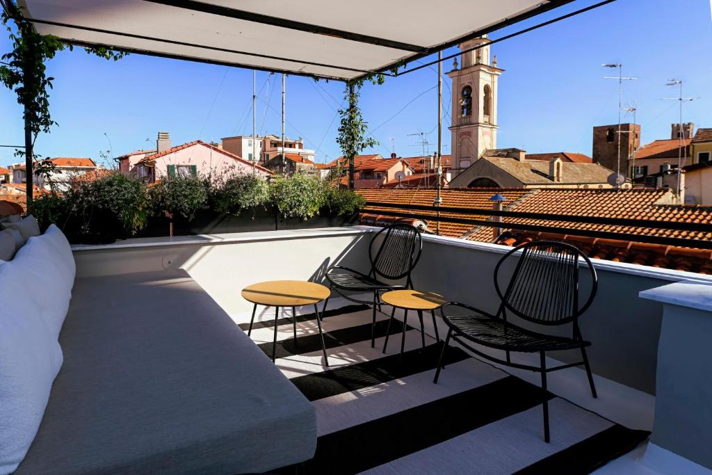 two chairs and two tables on a rooftop balcony at Torri e tramonti in Albenga