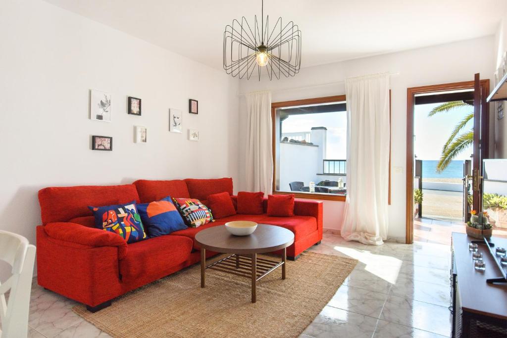 a living room with a red couch and a table at Salitre in Playa Honda