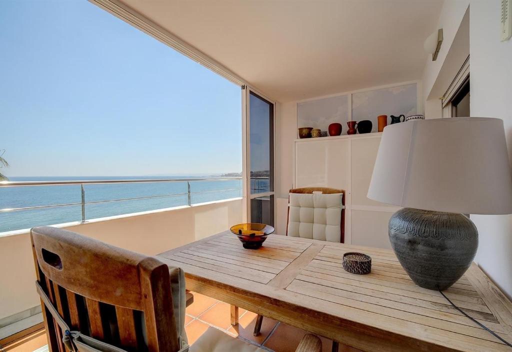 a dining room table with a lamp and a view of the ocean at Apartment Boulevard 105 in Estepona