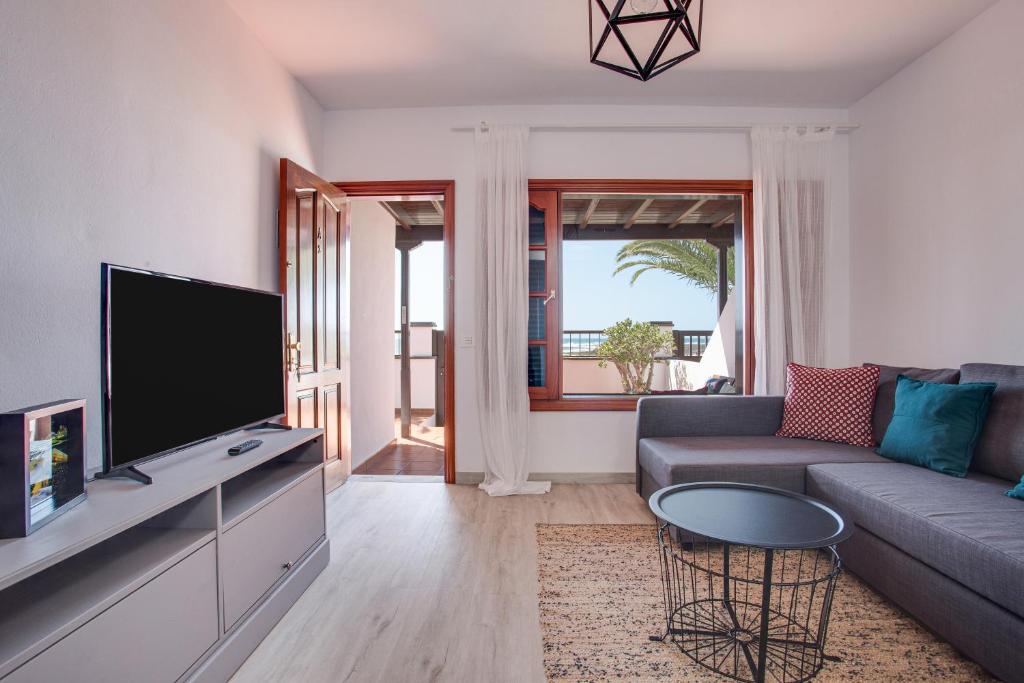 a living room with a couch and a tv at Casa Ann in Arrecife