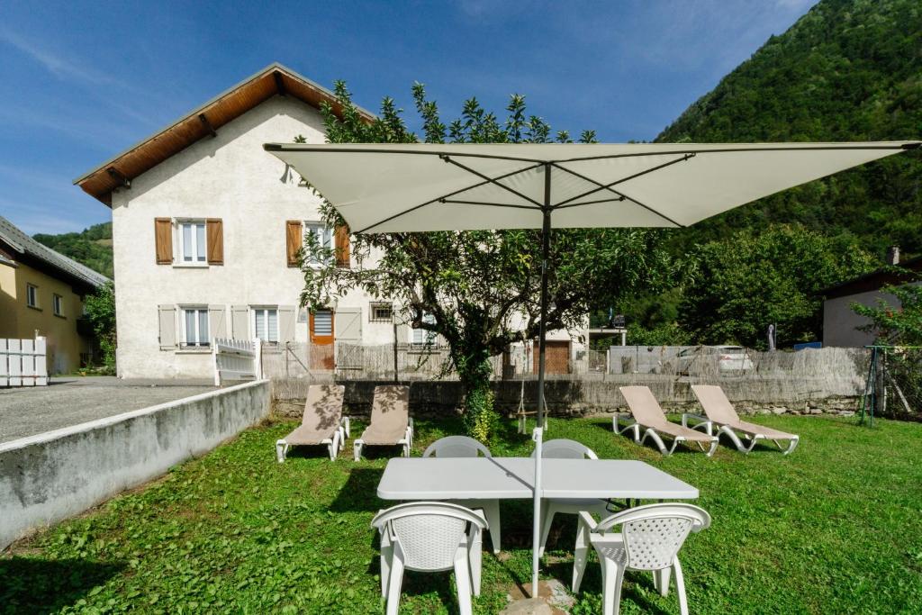 a white table and chairs with a white umbrella at Gîte Zen Attitude in Saint-Martin-sur-le-Chambre