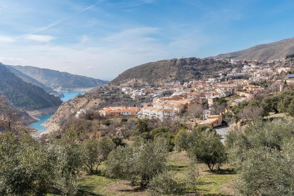 a view of a town on a hill with a river at Apartamentos cuna del Genil in Güéjar-Sierra