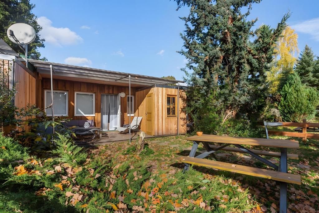 a wooden house with a picnic table in the yard at Ferienhaus 203 in Zadelsdorf
