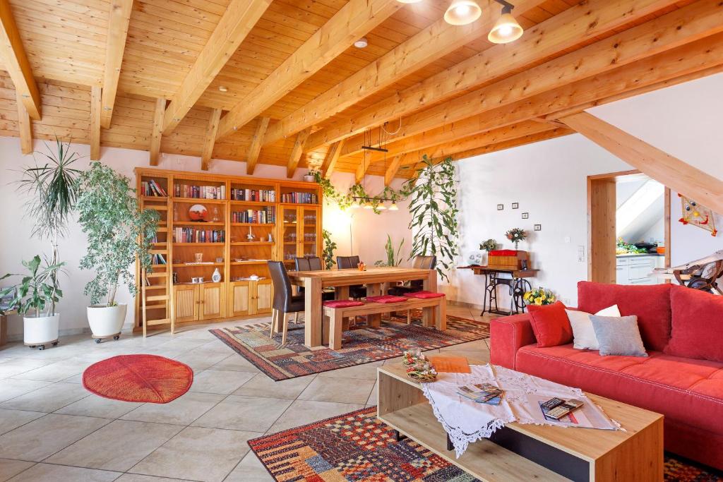a living room with a red couch and a table at Ferienwohnung am Rosenberg in Stockach