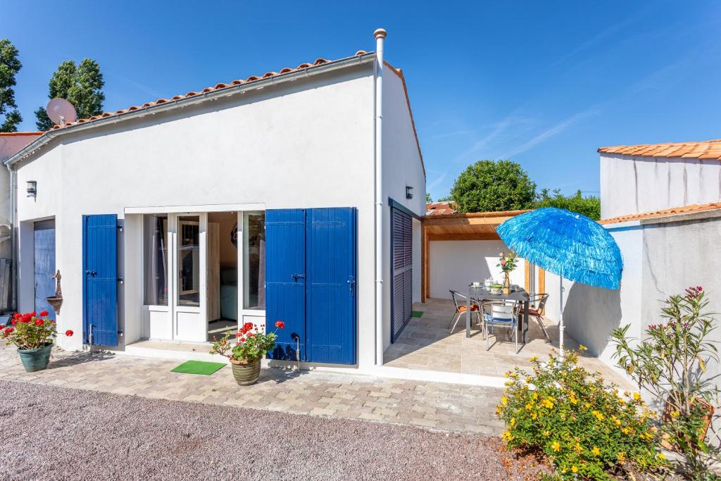 a house with blue doors and a patio at Le Petit Appartement de Saint-Denis in Saint-Denis-dʼOléron