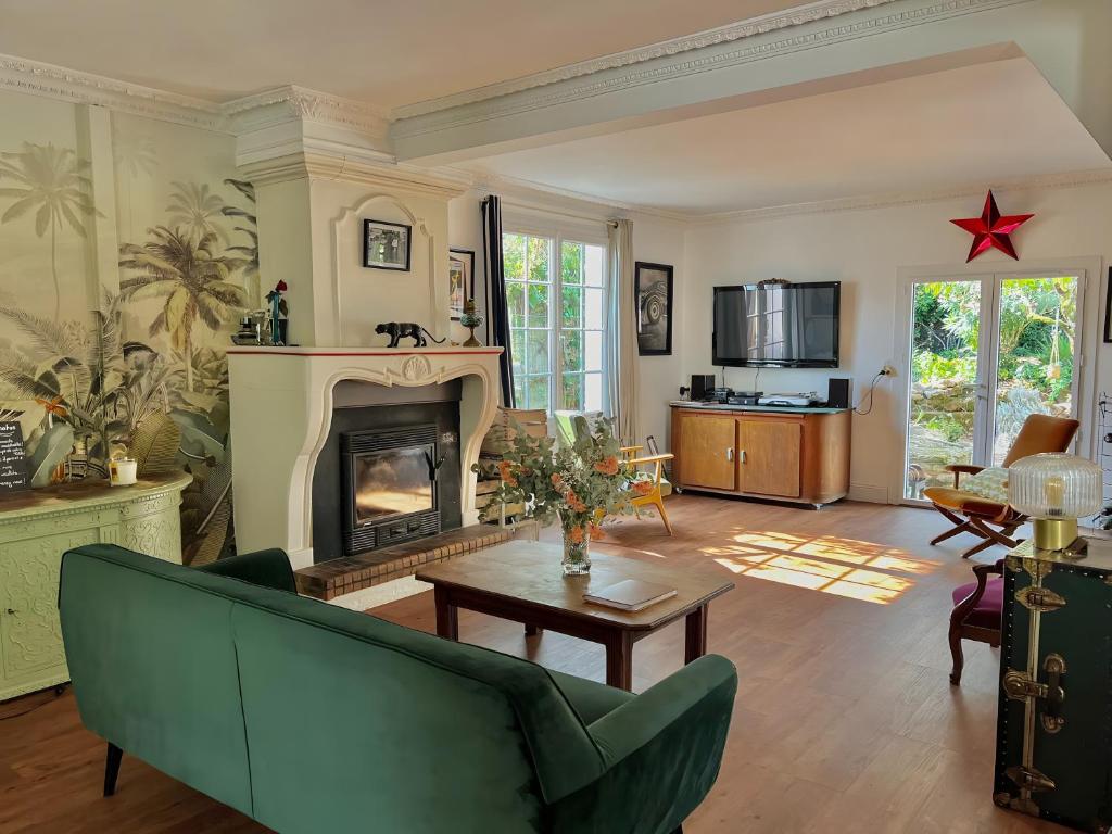 a living room with a green couch and a fireplace at Villa Esterel, Pour 14 Pers in La Faute-sur-Mer