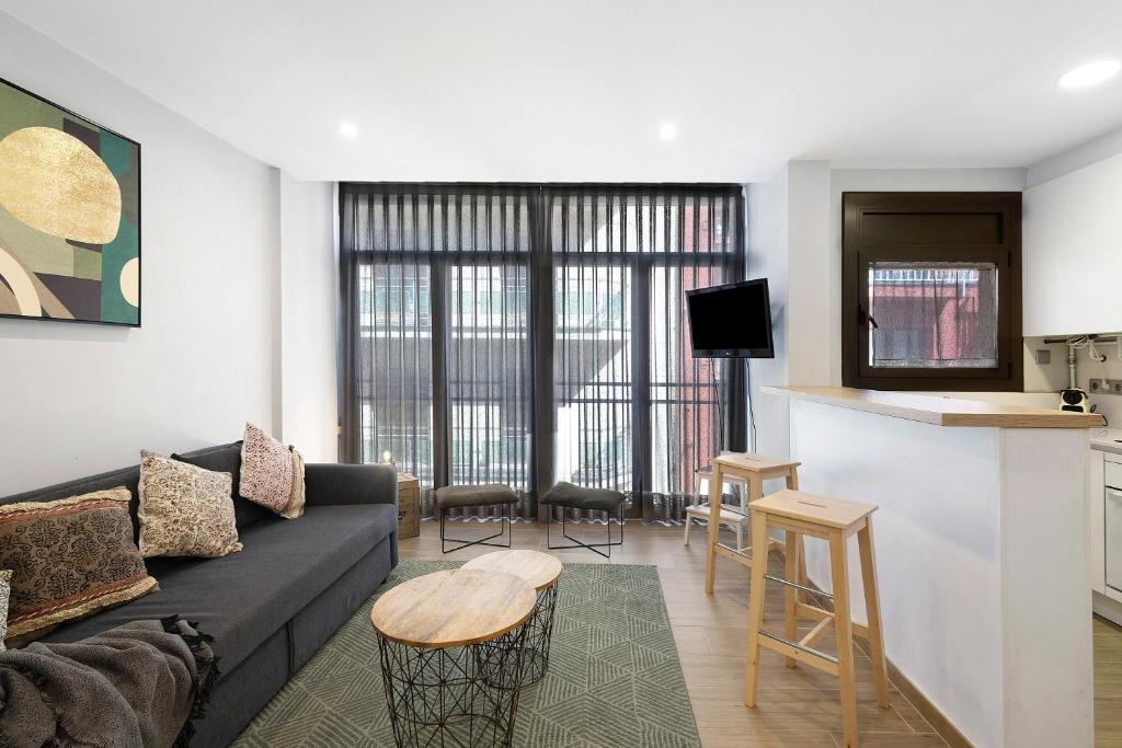 a living room with a couch and a kitchen at Alfons I in Puigcerdà