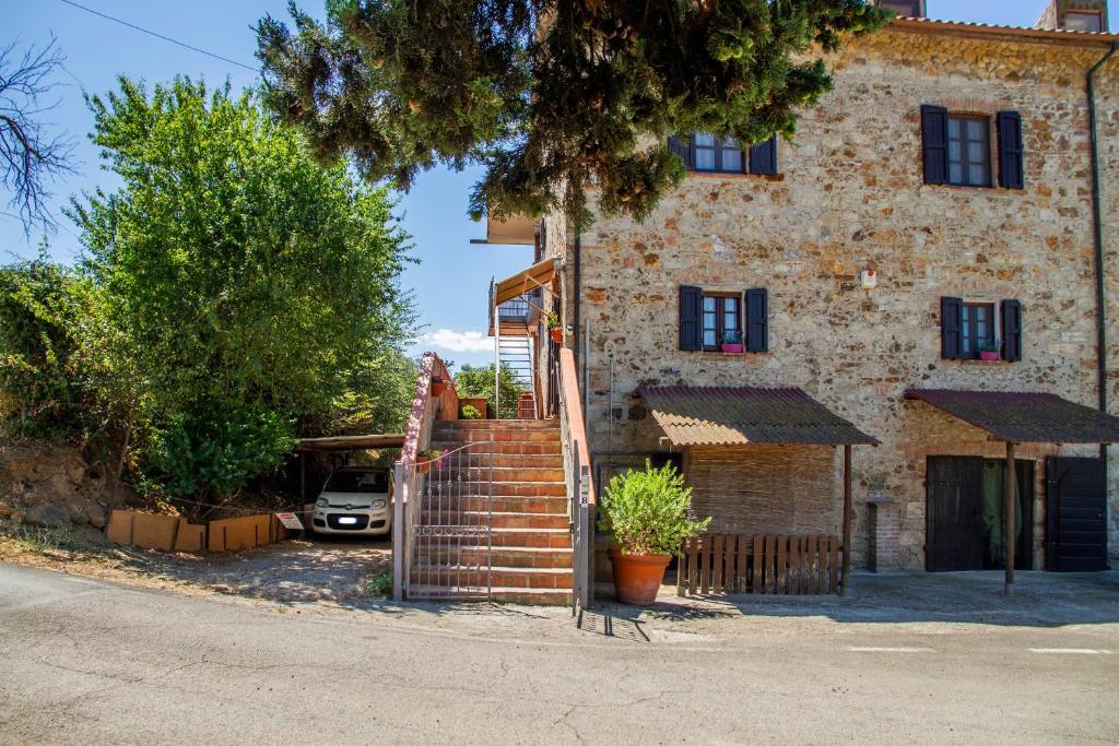 a house with a staircase in front of a building at Vecchio Molino in Gavorrano