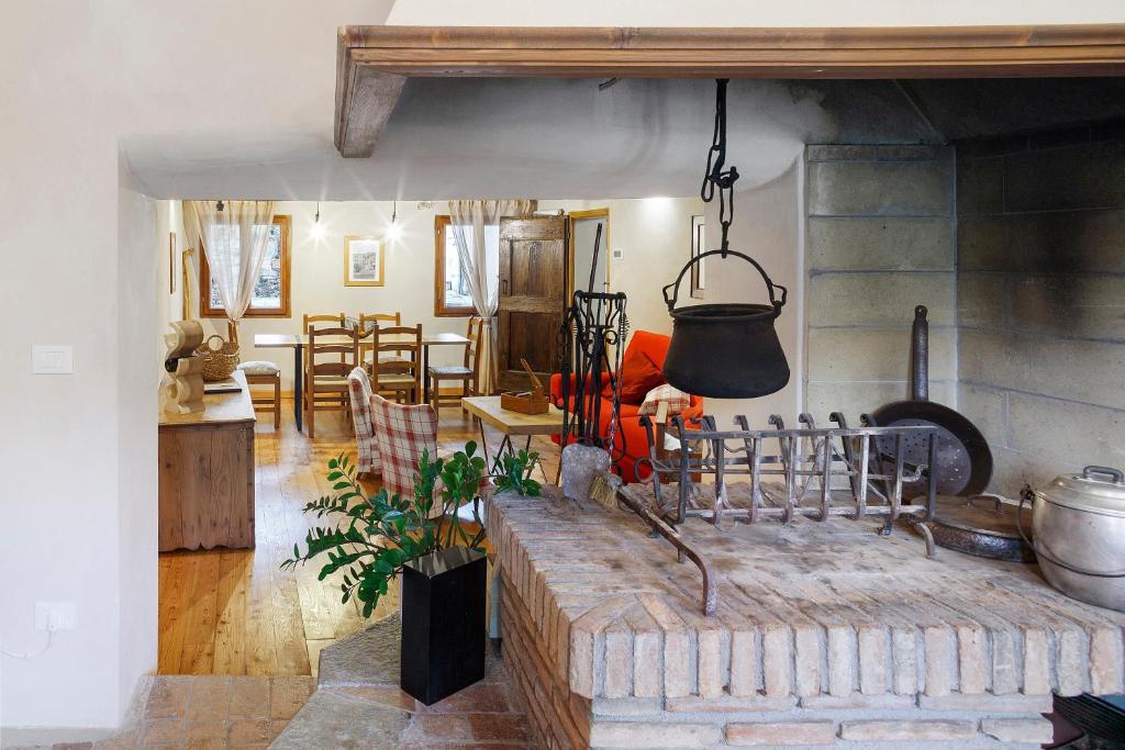 a kitchen and living room with a pot hanging from the wall at Villa Il Cortivo 81 in Fratta