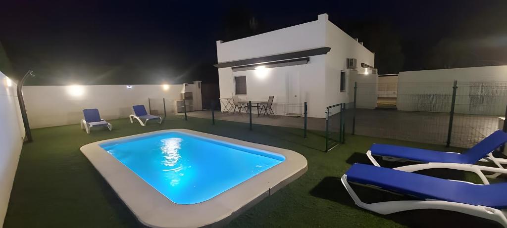 a large swimming pool with chairs and a table at Casa Alex 1 in Zahora