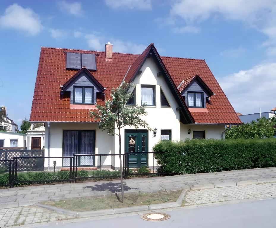 a white house with a red roof at Haus Arvert in Koserow