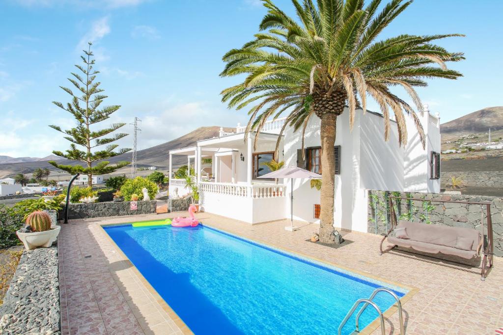 a villa with a swimming pool and a palm tree at Casa Salinoco in Mácher
