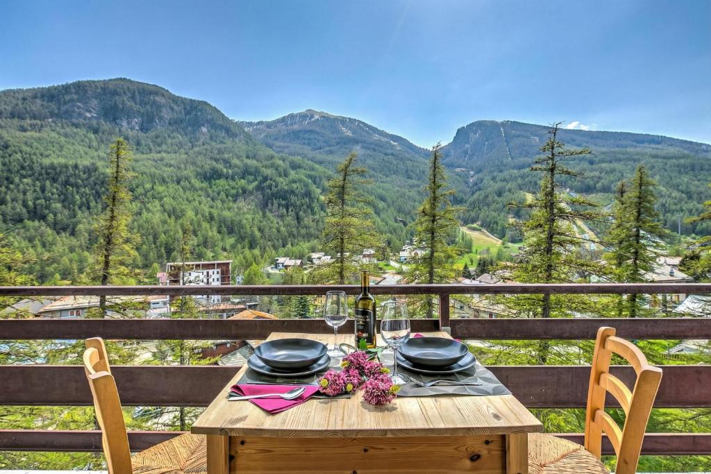a wooden table with a plate of food on a balcony at Starkeeper Apartment - Happy Rentals in Pragelato