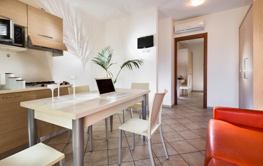 kuchnia i jadalnia z laptopem na stole w obiekcie Milano Family Suite w mieście Bellaria-Igea Marina