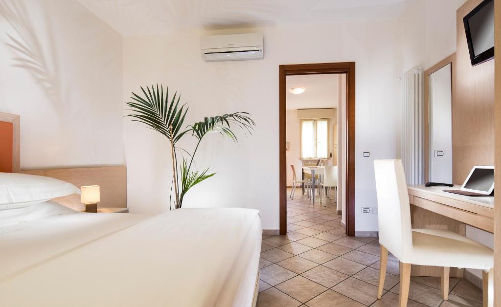 sypialnia z łóżkiem i biurkiem z laptopem w obiekcie Milano Family Suite w mieście Bellaria-Igea Marina